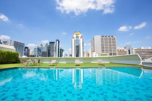 曼谷Graceland Bangkok by Grace Hotel - SHA Extra Plus的一座大型游泳池,其背景是城市天际线