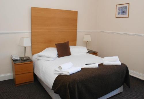 邓凯尔德博南姆酒店的一间卧室配有一张大床和毛巾