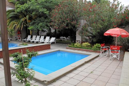 圣路易斯艾伊洛酒店的一个带桌子、遮阳伞和椅子的游泳池