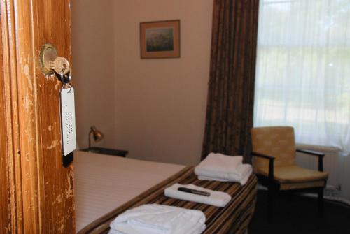 邓凯尔德博南姆酒店的配有一张床和一把椅子的酒店客房