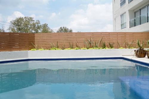 瓜达拉哈拉Metropolitan Suites的后院的游泳池,带有木栅栏
