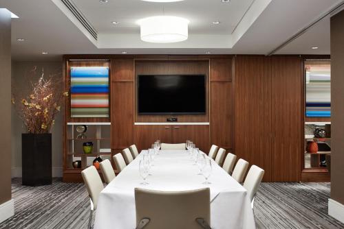 纽约格兰德中央精品酒店的一间配备有桌椅及电视的会议室