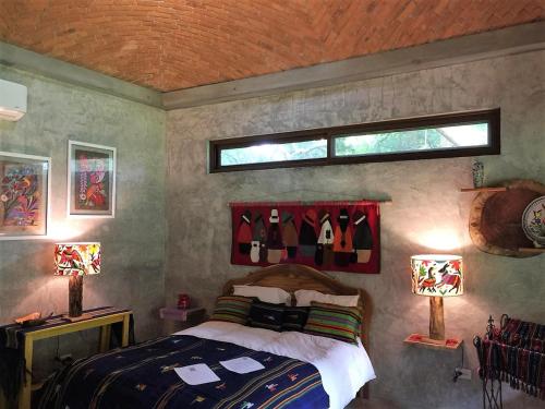 圣卡洛斯VillaHermosa B&B的一间卧室配有一张床、两盏灯和一个窗户。