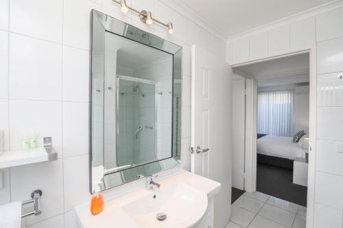 米尔迪拉112号橄榄公寓的白色的浴室设有水槽和镜子