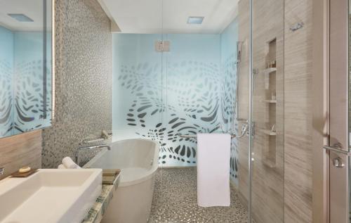 阿布扎比Royal M Hotel Abu Dhabi by Gewan的带浴缸、卫生间和淋浴的浴室。