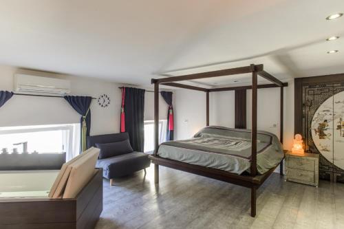 那不勒斯luxury suite San Carlo的一间卧室配有一张天蓬床和一把椅子