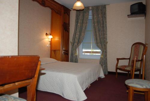 蓬托尔松法兰西酒店的一间卧室配有一张床、一张书桌和一个窗户。