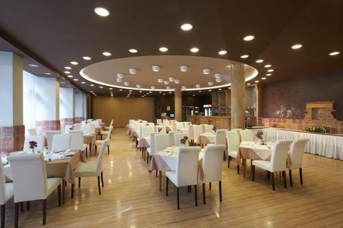 佩奇Laterum Economy的用餐室配有白色的桌子和白色的椅子