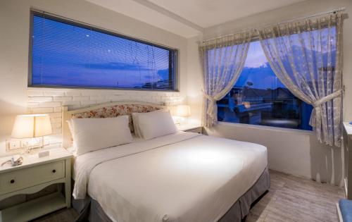 万隆Summerbird - Bed and Brasserie的一间卧室设有一张大床和一个大窗户