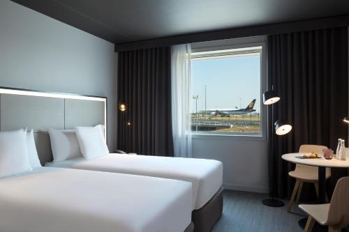 鲁瓦西昂法兰西INNSiDE by Meliá Paris Charles de Gaulle Airport的酒店客房设有两张床和窗户。