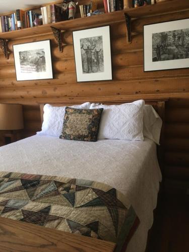 布拉夫Canyon Wren Bed and Breakfast的卧室配有一张墙上挂有照片的床