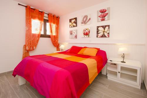 卡门港托佩斯公寓的一间卧室配有一张带彩色毯子的床
