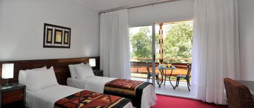 伊瓜苏港格兰托比伦酒店的酒店客房设有两张床和一个阳台。