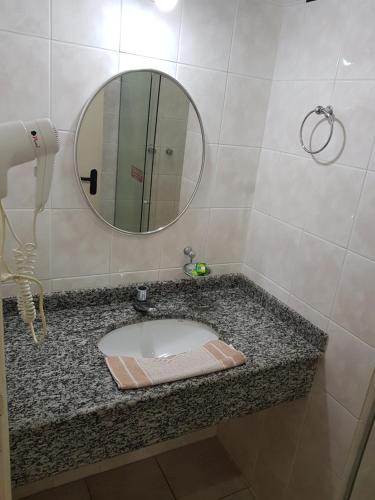 雷吉斯特鲁Hotel Valle Sul的浴室设有水槽和镜子,位于柜台上