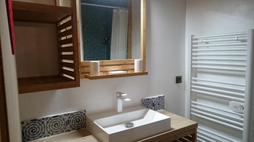 莫里永Les Oiseaux Bleus的浴室设有白色水槽和镜子
