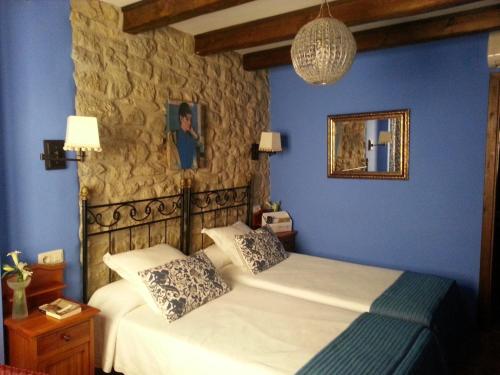 索斯-德尔雷卡托利科英范恩颂酒店的一间蓝色卧室,配有一张床和镜子