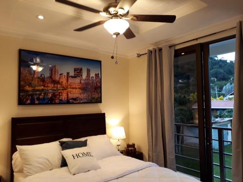 下博克特Mirango Apartments的一间卧室配有一张带吊扇和窗户的床。