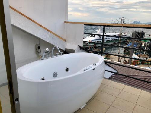 仙本那The Wharf的浴缸位于享有水景的客房内