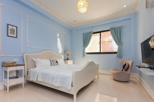 吉安法式棉花糖民宿的蓝色的卧室设有床和窗户