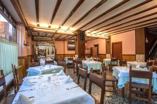 Alcorisa城堡餐厅及酒店的一间带桌椅和蓝桌布的用餐室