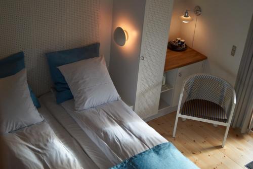 亨讷斯特兰德Henne Mølle Å Badehotel的一间小卧室,配有一张床和一把椅子