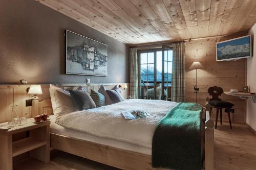 克洛斯特斯阿尔盆罗斯里旅馆的一间卧室设有一张带木制天花板的大床