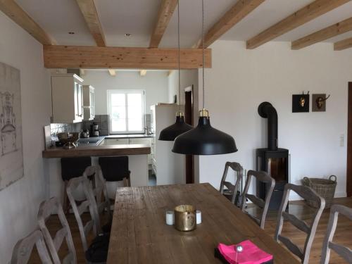 普特布斯Hof Vilmnitz Haus B的厨房以及带木桌和椅子的用餐室。