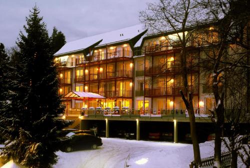 奥伯霍夫奥贝罗夫松恩航小木屋公寓式酒店的一座大建筑,有灯光在雪中