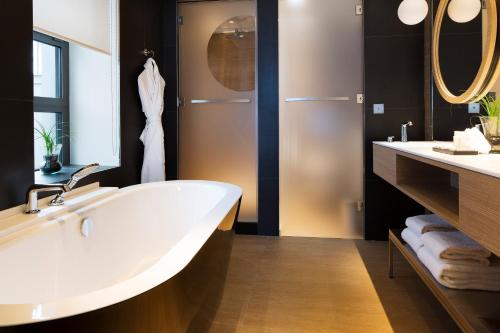 巴黎三科考德旅馆的浴室配有大型白色浴缸和2个盥洗池
