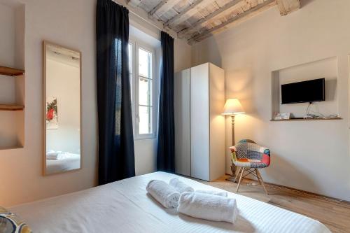 佛罗伦萨Mamo Florence - Boheme Apartment的一间卧室配有一张床、一把椅子和电视