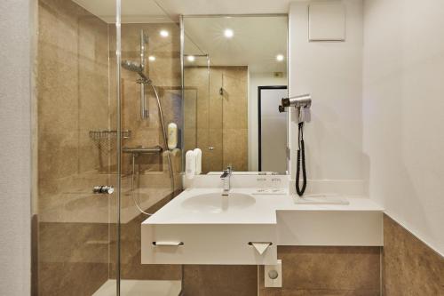 布吕尔科隆布吕尔H +酒店的一间带水槽和淋浴的浴室