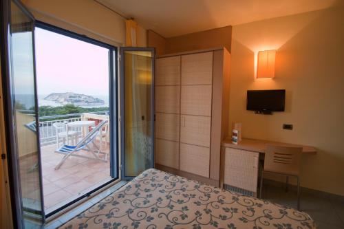 圣多米诺加比阿诺酒店的一间卧室设有一张床,享有阳台的景色