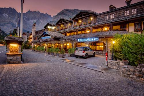 库马约尔iH Hotels Courmayeur Mont Blanc的停在一座山楼前的汽车