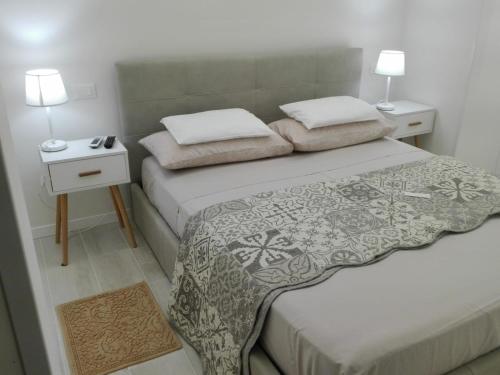 圣雷莫La Casa Di Pepe的一间卧室设有两张床和两个床头柜