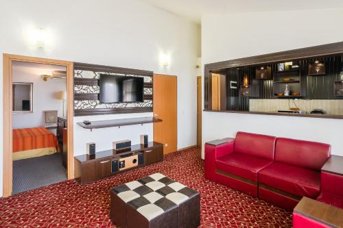 布加勒斯特索非亚别墅的酒店客房配有红色的沙发和床。