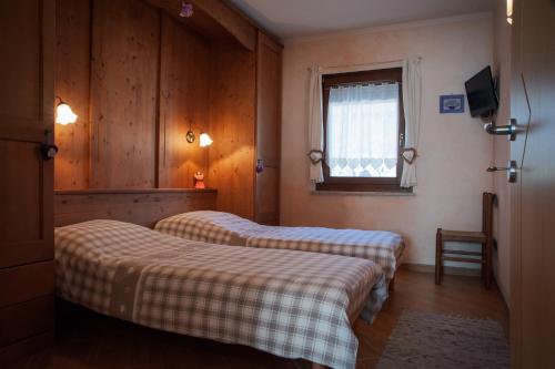 费拉迪普利米罗Casa Gabriella的客房设有两张床和窗户。