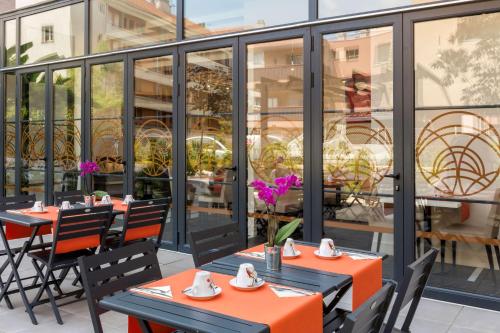 圣罗兰度瓦Best Western Hôtel Journel Saint-Laurent-du-Var的餐厅庭院里摆放着一排桌椅