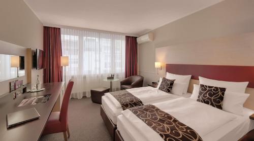 达姆施塔特Best Western Hotel Darmstadt Mitte的酒店客房设有一张大床和一张书桌。