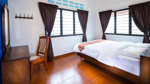 丰盛港辛村度假屋的一间卧室配有一张床、一张书桌和两个窗户。
