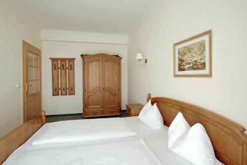 卡罗维发利罗萨别墅酒店的一间卧室配有一张床和一个木制橱柜