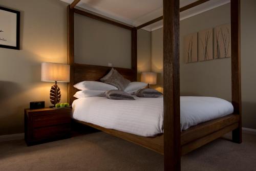 奇切斯特Crouchers Hotel的卧室配有带白色床单和枕头的天蓬床。