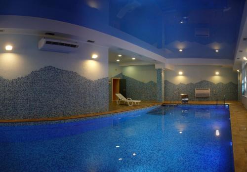 基兹洛沃茨克Kolizey Hotel的蓝色灯光的酒店游泳池