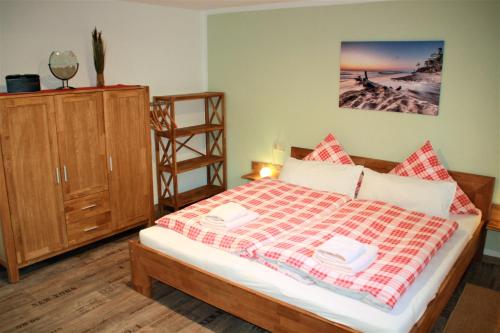 普雷罗Heuser Prerow Ferienunterkünfte的一间卧室配有一张床和一个木制橱柜