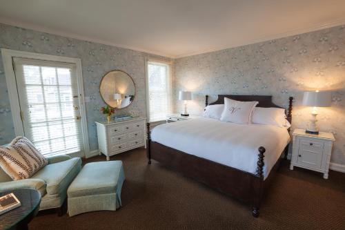 五月岬郡The Virginia and Cottages的一间卧室配有一张床、一把椅子和镜子