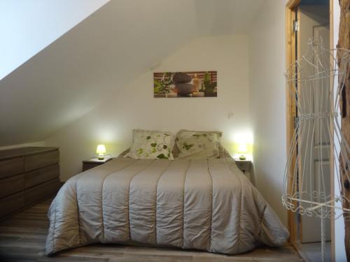 圣欧班堡Charmante maison Solognote rénovée的卧室内的一张床位,配有两盏灯和一个楼梯