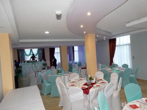 雅温得Safyad Hotel的宴会厅配有白色的桌椅