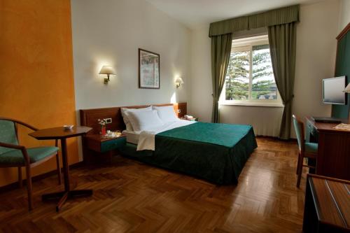 阿奇雷亚莱格兰蒂艾尔伯格蒙杰利酒店的酒店客房设有床、桌子和窗户。