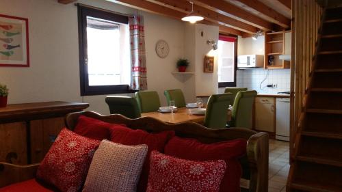 莱德萨阿尔卑斯娄维诺公寓的一间带桌子和绿色椅子的用餐室