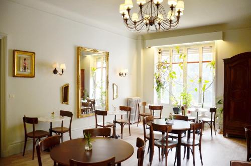 比亚里茨Saint Charles Hôtel & Coliving Biarritz的一间带桌椅和镜子的用餐室