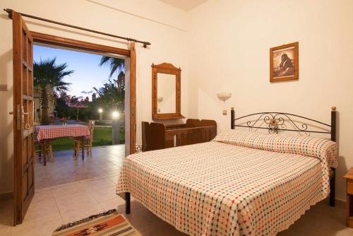 RizokarpasoGlaro Garden Hotel的一间卧室设有一张床,并有通往庭院的门